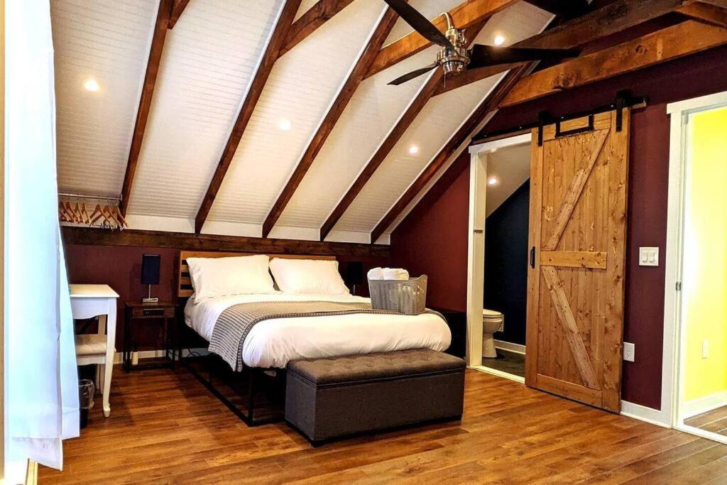 una camera con un letto in una stanza con soffitto in legno di Walkable Elmwood Cottage, No Chores 2Bath 2BR 2Car a Buffalo