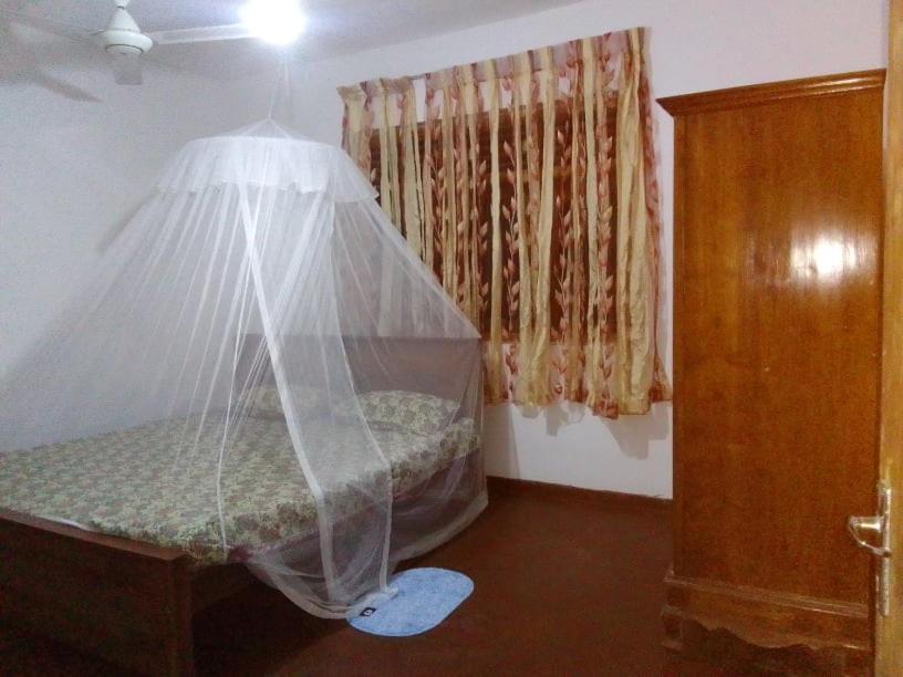Un dormitorio con una cama con una red. en Tinu Homestay en Mirissa