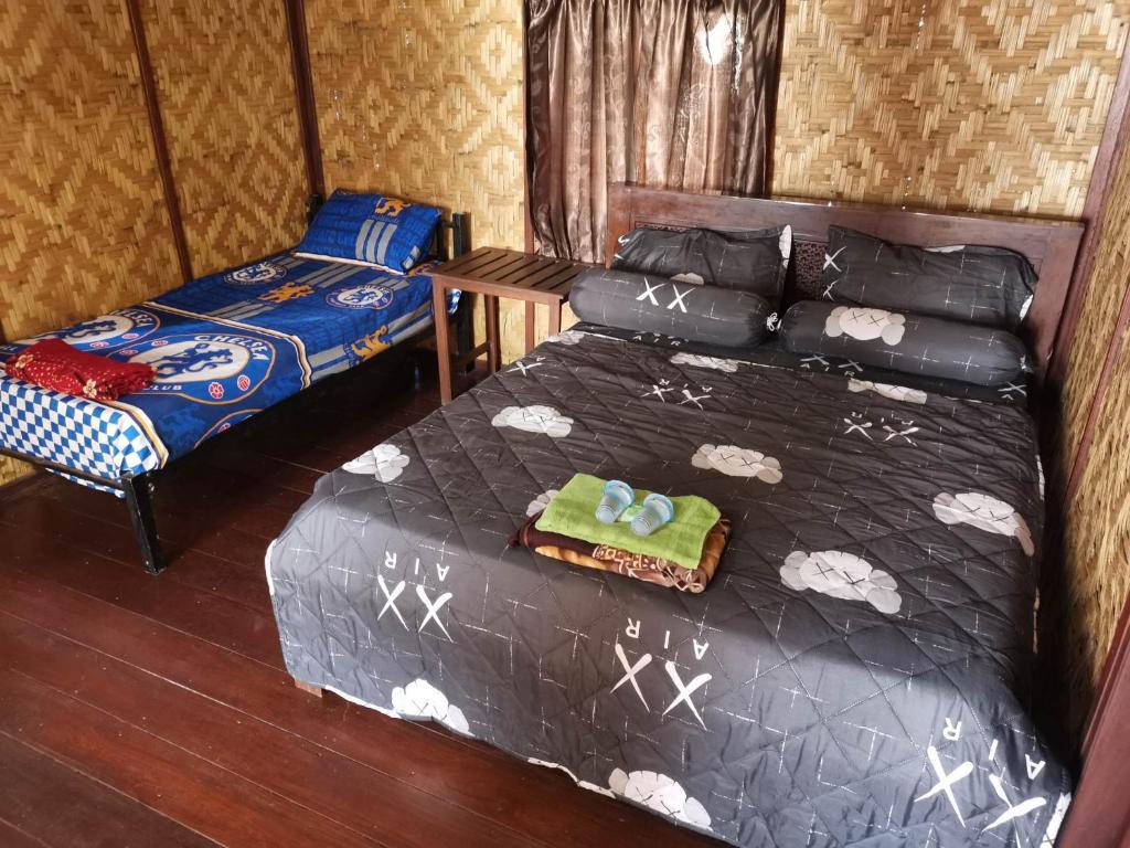 ein Schlafzimmer mit einem Bett, einem Bett und einem Stuhl in der Unterkunft Villa panrangluhu in Bira