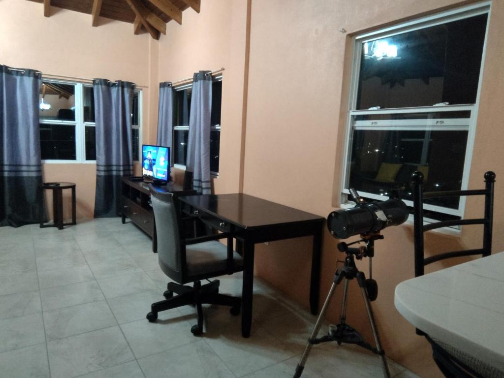 a room with a desk with a computer and a camera at Zeus Guesthouse in Grays Hill