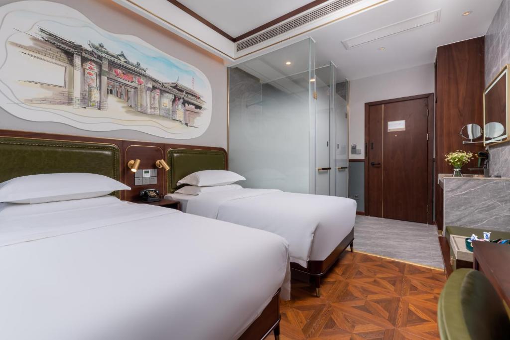 a hotel room with two beds and a bathroom at Nost algia S Hotel Near Chengdu Kuanzhai Alley - People's Park, Chengdu Panda Base, 10 minutes walk to subway , Free laundry, English communication well, Free coffee,Free travel advice in Chengdu