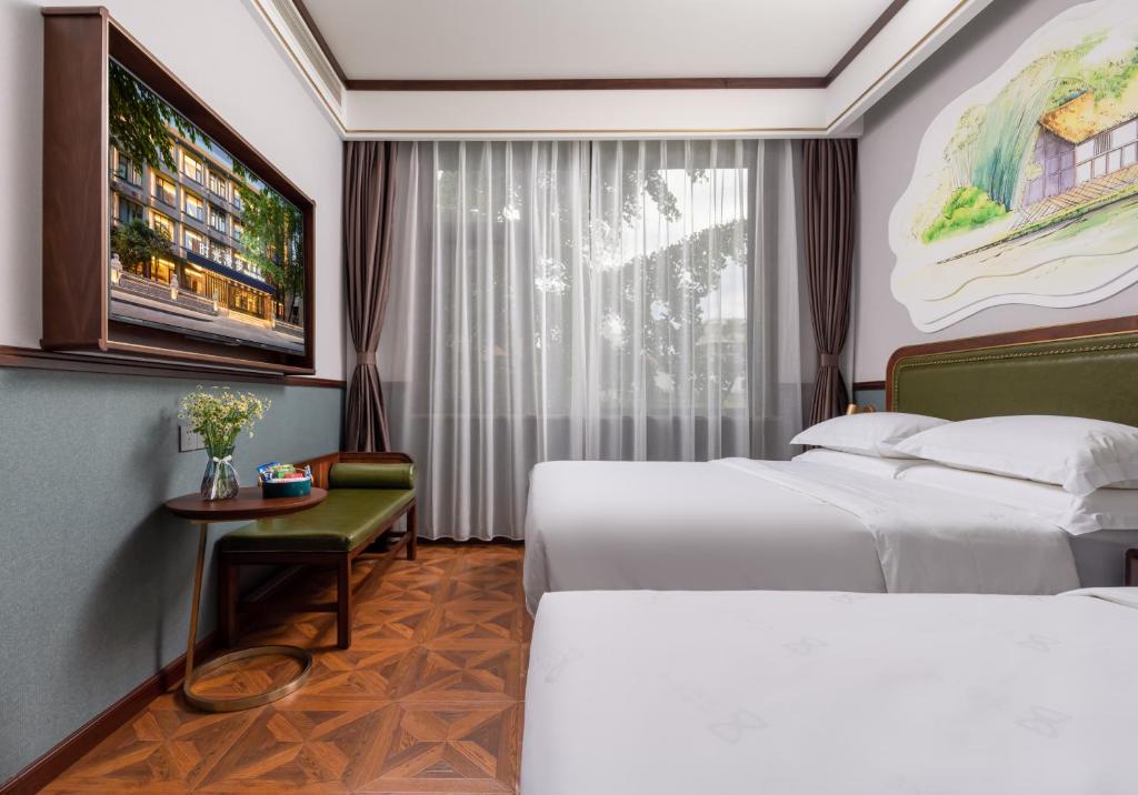 a hotel room with two beds and a tv at Nost algia S Hotel Near Chengdu Kuanzhai Alley - People's Park, Chengdu Panda Base, 10 minutes walk to subway , Free laundry, English communication well, Free coffee,Free travel advice in Chengdu