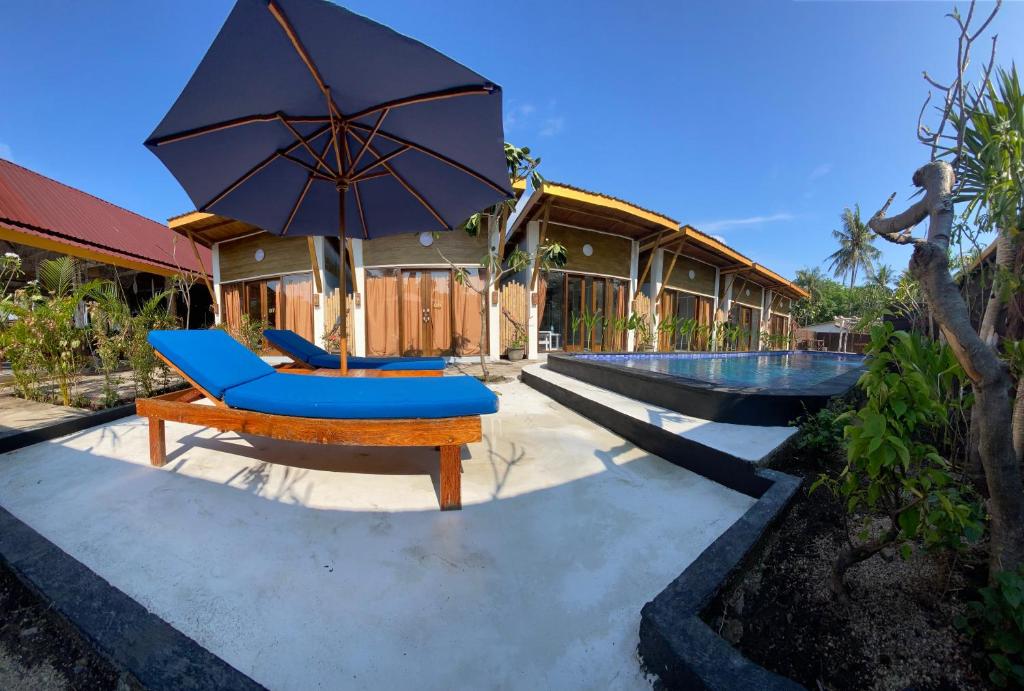 - une terrasse avec une chaise et un parasol à côté de la piscine dans l'établissement SUN RESORT GILI TRAWANGAN, à Gili Trawangan