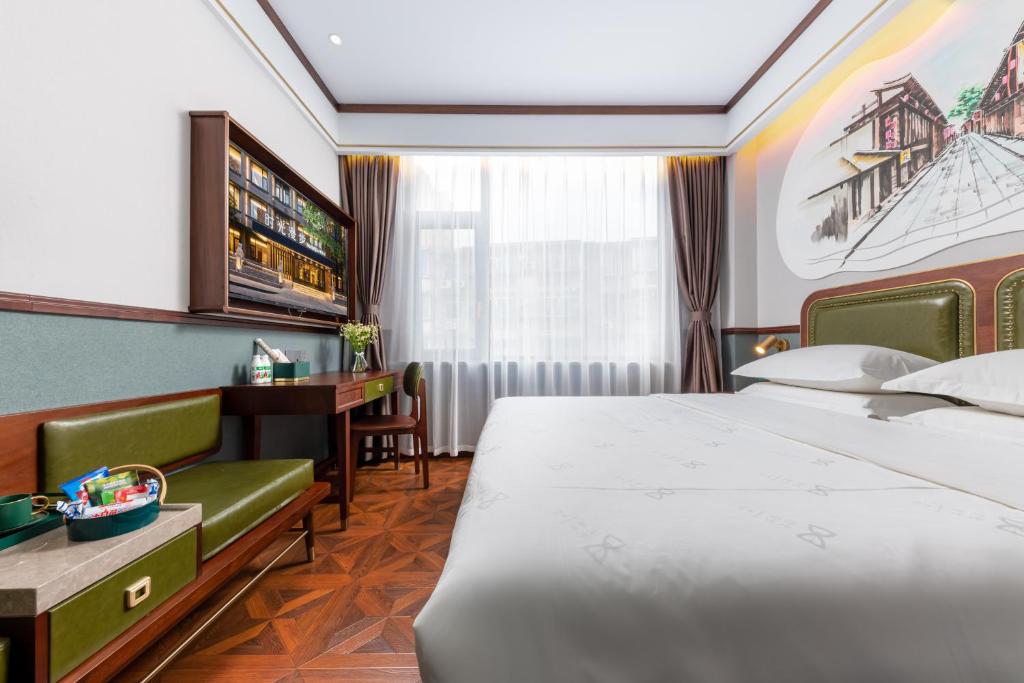 a hotel room with a bed and a desk at Nost algia S Hotel Near Chengdu Kuanzhai Alley - People's Park, Chengdu Panda Base, 10 minutes walk to subway , Free laundry, English communication well, Free coffee,Free travel advice in Chengdu
