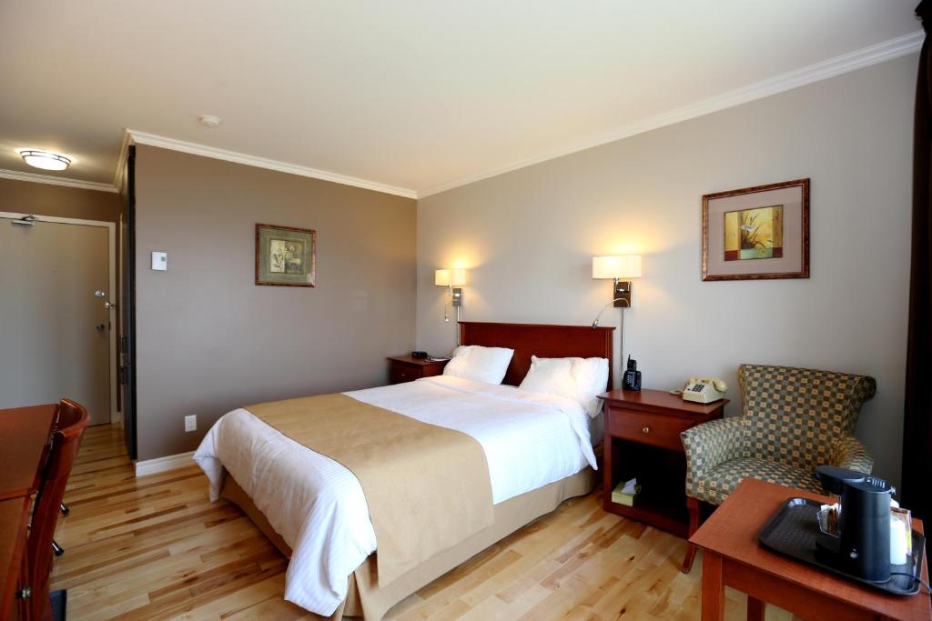 Habitación de hotel con cama, escritorio y silla en Auberge des Battures, en La Baie