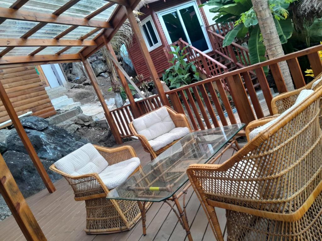 a patio with chairs and a glass table on a deck at Casa de Diamantes in Tela