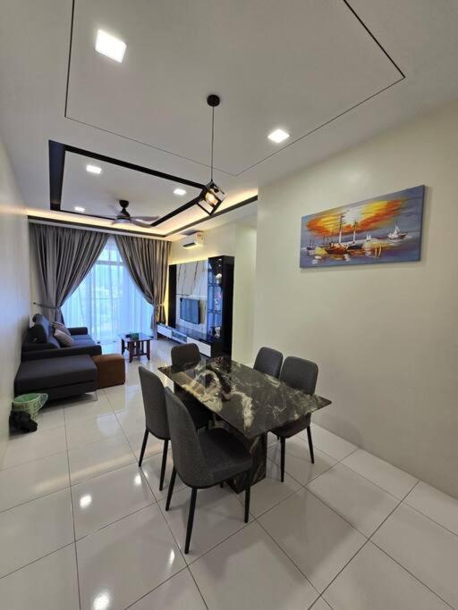 uma sala de jantar com mesa e cadeiras e uma sala de estar em Stay @ 71 Oasis Condominium Ipoh em Ipoh