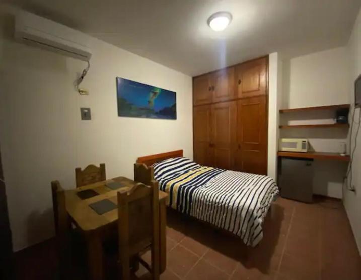 a bedroom with a bed and a table and a desk at VILLAS IXCHEL in Tapachula