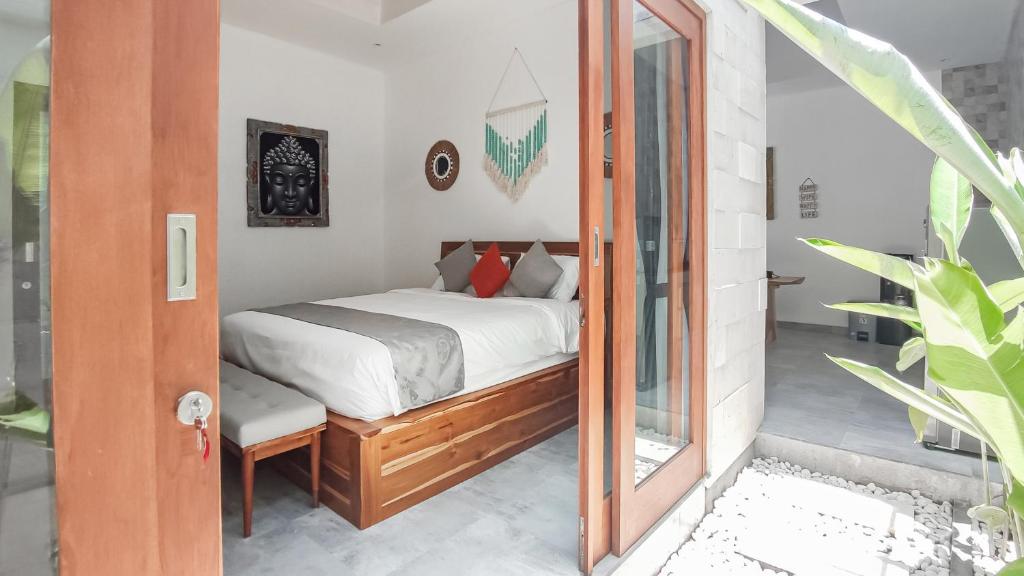 a bedroom with a bed and a mirror at Calm Woods Villa Near Pandawa Beach in Nusa Dua