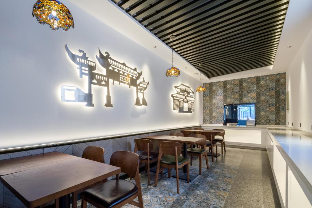 a restaurant with tables and chairs in a room at Nost algia S Hotel Near Chengdu Kuanzhai Alley - People's Park, Chengdu Panda Base, 10 minutes walk to subway , Free laundry, English communication well, Free coffee,Free travel advice in Chengdu