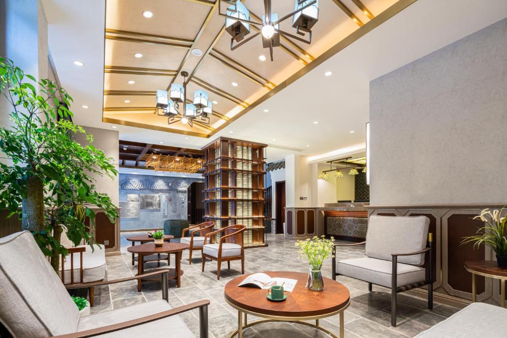 a lobby of a hotel with tables and chairs at Nost algia S Hotel Near Chengdu Kuanzhai Alley - People's Park, Chengdu Panda Base, 10 minutes walk to subway , Free laundry, English communication well, Free coffee,Free travel advice in Chengdu