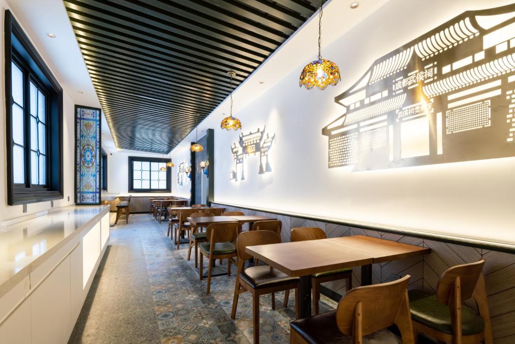 a row of tables and chairs in a restaurant at Nost algia S Hotel Near Chengdu Kuanzhai Alley - People's Park, Chengdu Panda Base, 10 minutes walk to subway , Free laundry, English communication well, Free coffee,Free travel advice in Chengdu