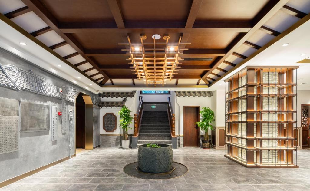 a lobby with a staircase and a chandelier at Nost algia S Hotel Near Chengdu Kuanzhai Alley - People's Park, Chengdu Panda Base, 10 minutes walk to subway , Free laundry, English communication well, Free coffee,Free travel advice in Chengdu