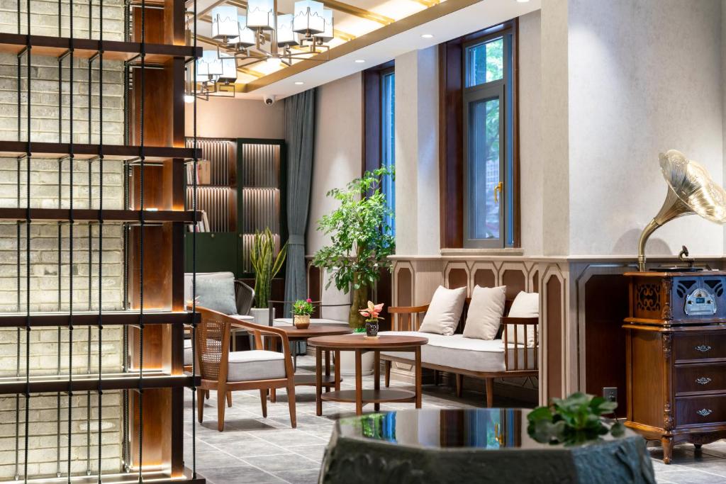 a living room with a couch and a table at Nost algia S Hotel Near Chengdu Kuanzhai Alley - People's Park, Chengdu Panda Base, 10 minutes walk to subway , Free laundry, English communication well, Free coffee,Free travel advice in Chengdu