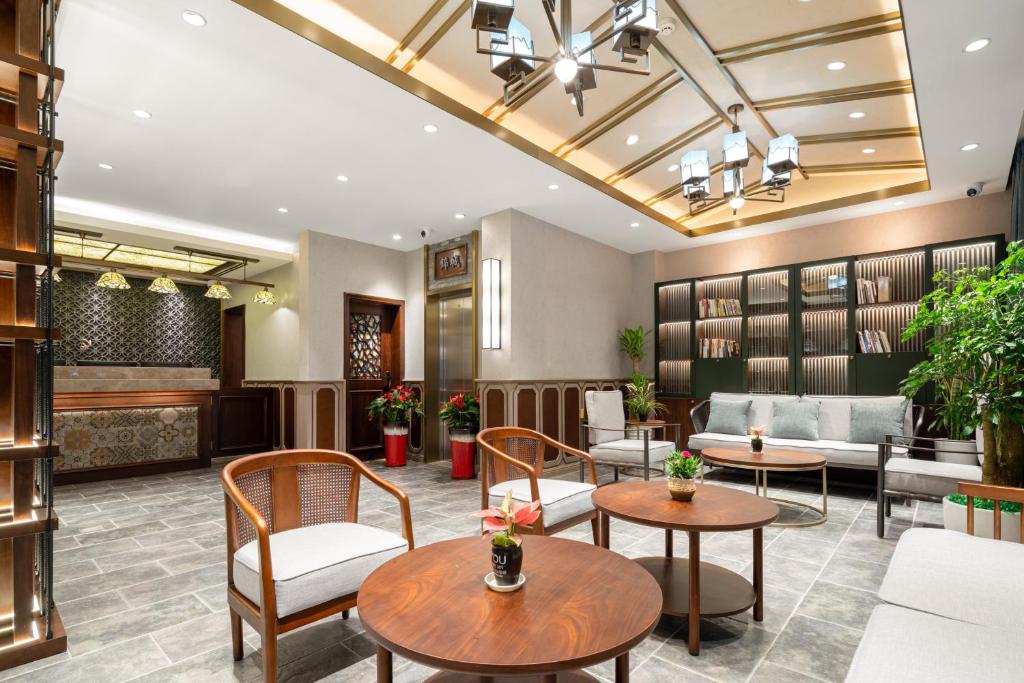 a lobby of a hotel with tables and chairs at Nost algia S Hotel Near Chengdu Kuanzhai Alley - People's Park, Chengdu Panda Base, 10 minutes walk to subway , Free laundry, English communication well, Free coffee,Free travel advice in Chengdu
