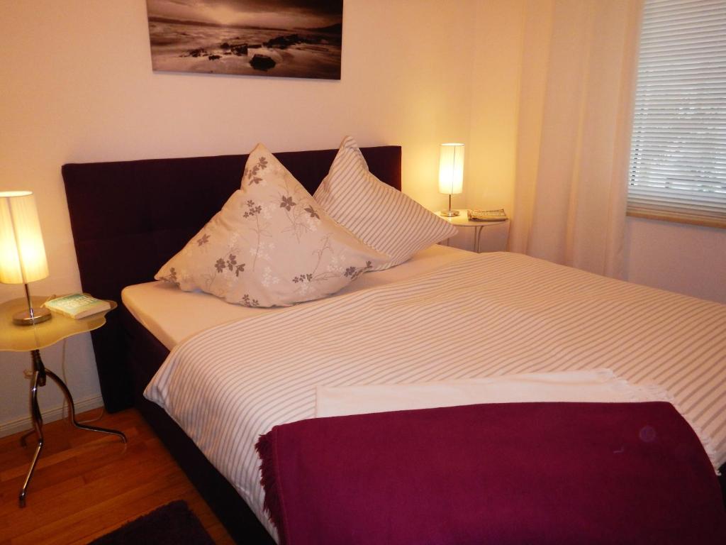 ein Schlafzimmer mit einem Bett mit Kissen darauf in der Unterkunft Gästehaus Mülheim in Mülheim an der Ruhr