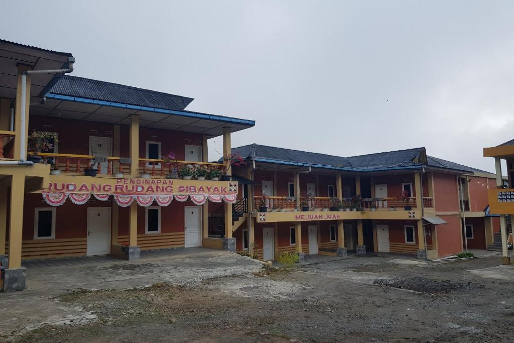 un edificio con un cartello che legge "ub stupefacenti elementi edilizi" di OYO 93780 Rudang Rudang Sibayak a Berastagi