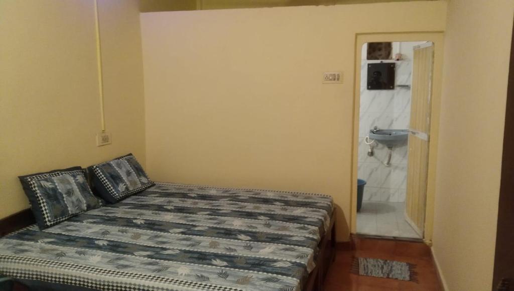1 dormitorio con 1 cama y baño con lavamanos en Laxmi Guest House (Arambol Beach) en Arambol