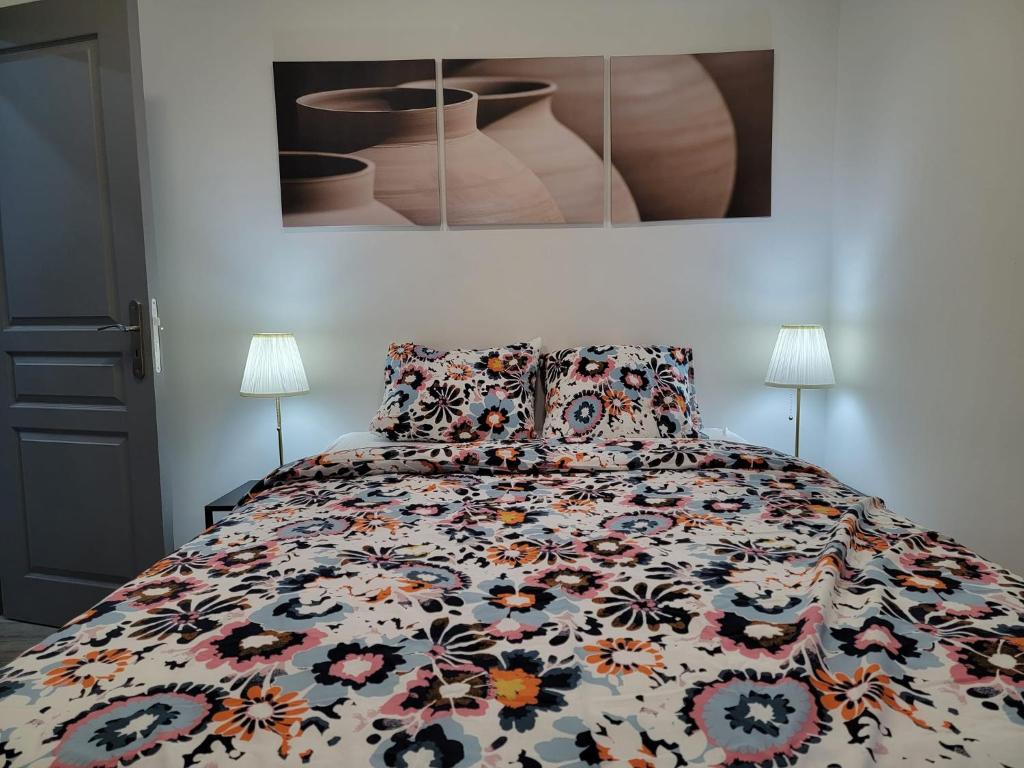 a bedroom with a bed with a colorful comforter at Les gîtes du Ravel in Soignies