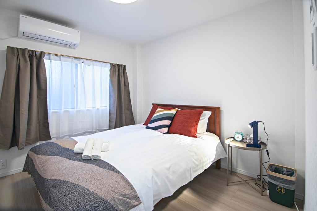 a bedroom with a bed and a window at - UMI-Haven 福島 - 隣駅5LDK戸建 in Osaka