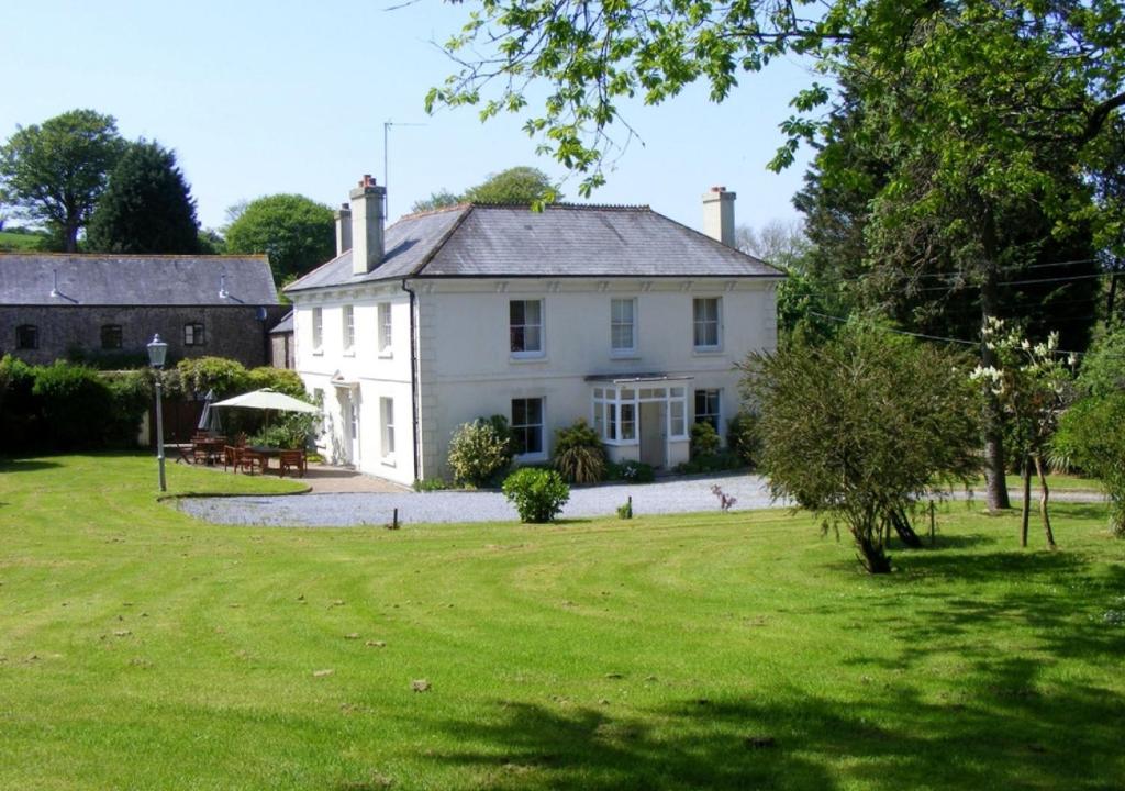 a large white house with a large yard at Buckland House in Slapton