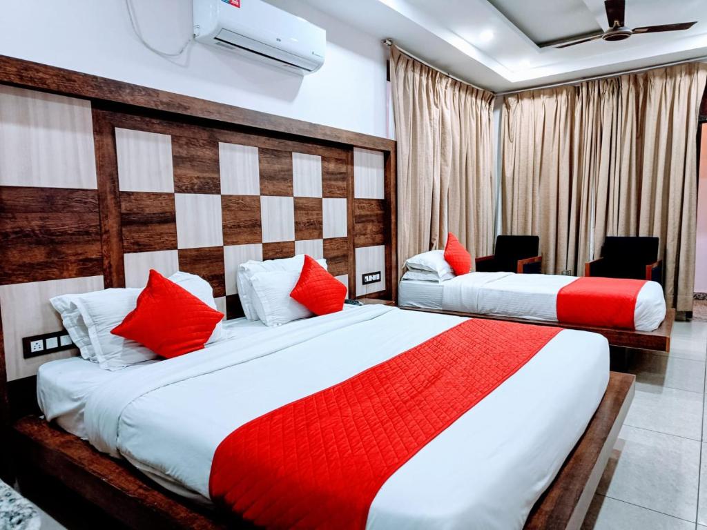 two beds in a hotel room with red pillows at Hotel The King near mall rd mcleodganj in Dharmsāla