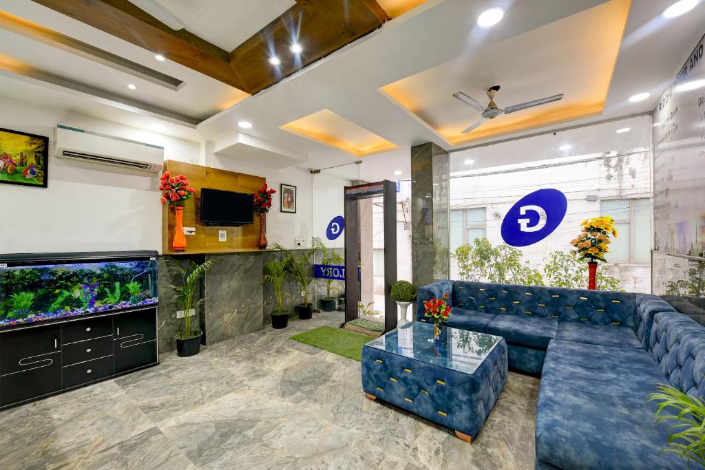 een woonkamer met een blauwe bank en een aquarium bij Hotel Grand Qubic Near Delhi Airport in New Delhi
