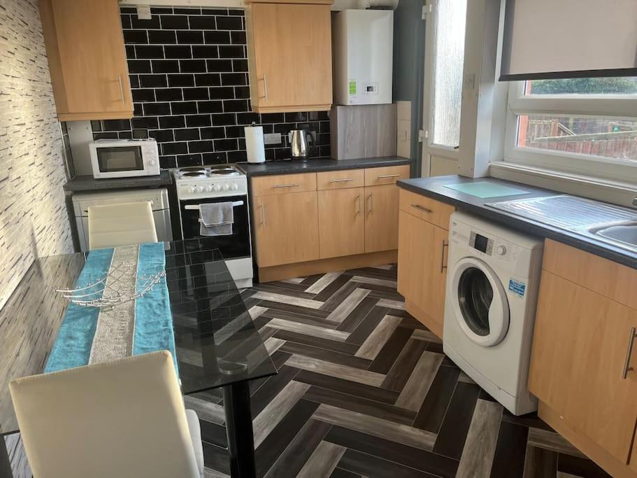 a kitchen with a table and a washing machine at 3 bed, entire house sleeps 6 ideal for tradesmen A in Airdrie