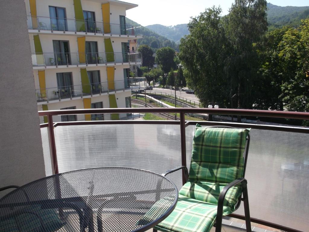 un balcón con mesa y silla y un edificio en PIKK Trenčianske Teplice, en Trenčianske Teplice