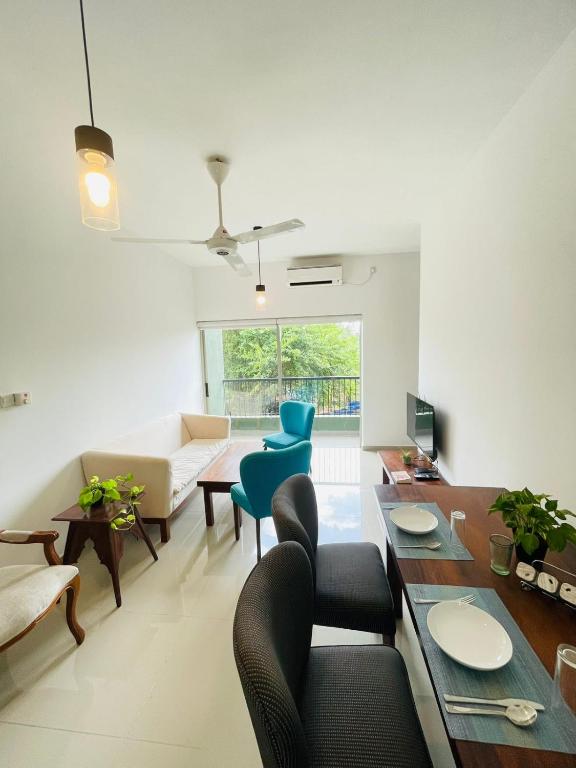 a living room with a couch and a table and chairs at Hideout Ariyana in Athurugiriya
