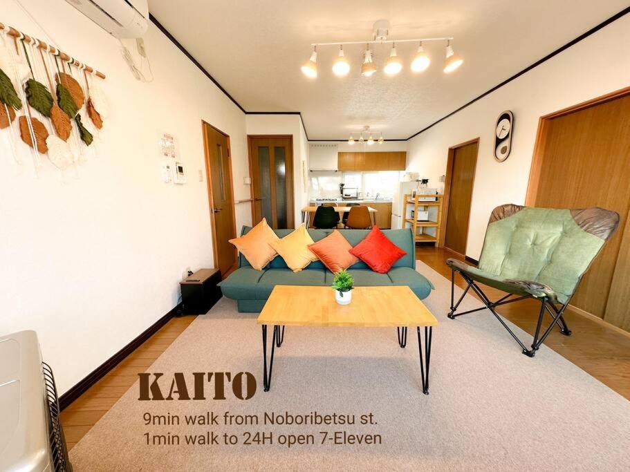 a living room with a couch and a table at Kaito/9min walk to Noboribetsu st. in Tomiura