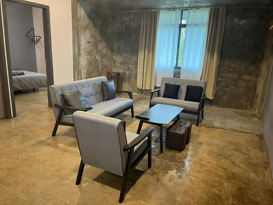 ein Wohnzimmer mit einem Sofa, Stühlen und einem Tisch in der Unterkunft JW Homestay (ShopHouse Lv2) in Kudat