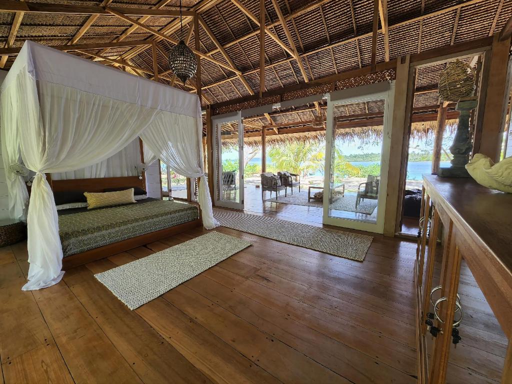 una camera con letto a baldacchino in un resort di Leleu Mentawai Accommodation a Tua Pejat