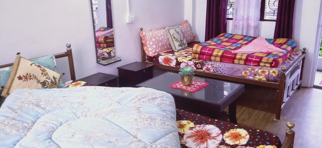 Sala de estar con cama y mesa en Shriya Homestay en Kurseong