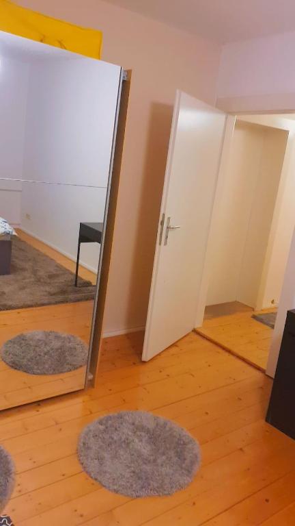 Habitación con espejo y 2 alfombras en el suelo en Home 2 Share in Braunschweig in der Nähe vom VW und Stadium., en Brunswick