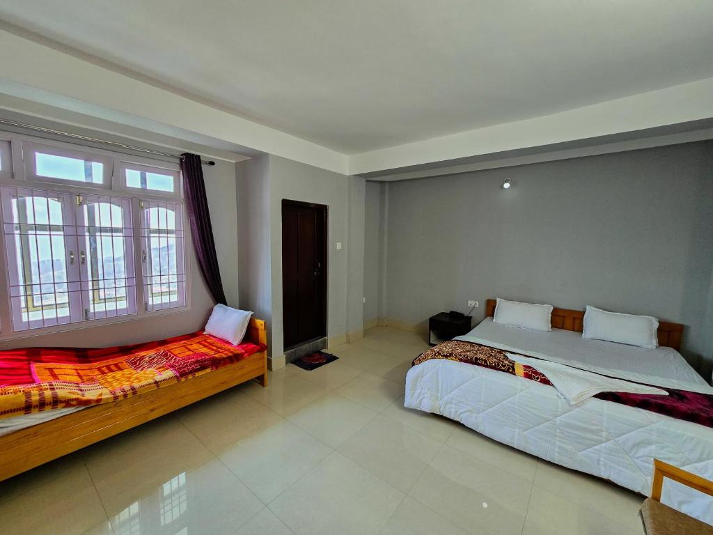 達旺鎮的住宿－Hotel Kimnas，一间卧室设有两张床和窗户。