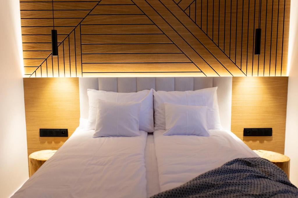 uma cama com lençóis brancos e almofadas num quarto em DOMKI NA LUZIE em Spytkowice