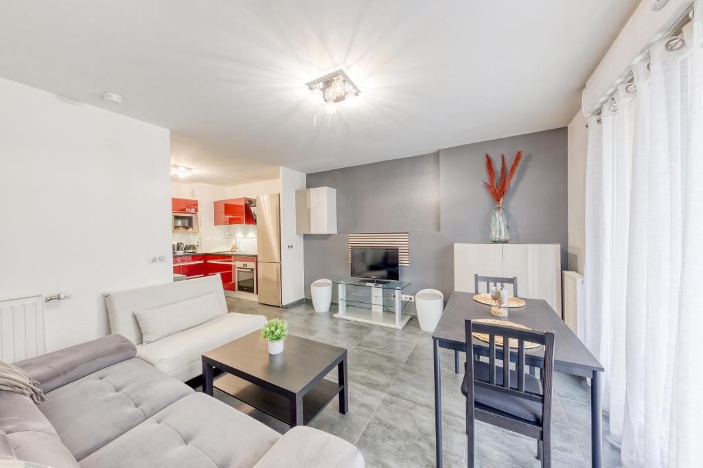 un salon avec un canapé et une table dans l'établissement Ô COCON DE FRANCONVILLE - LOGEMENT AVEC GRANDE TERRASSE - 24H ACCESS, à Franconville