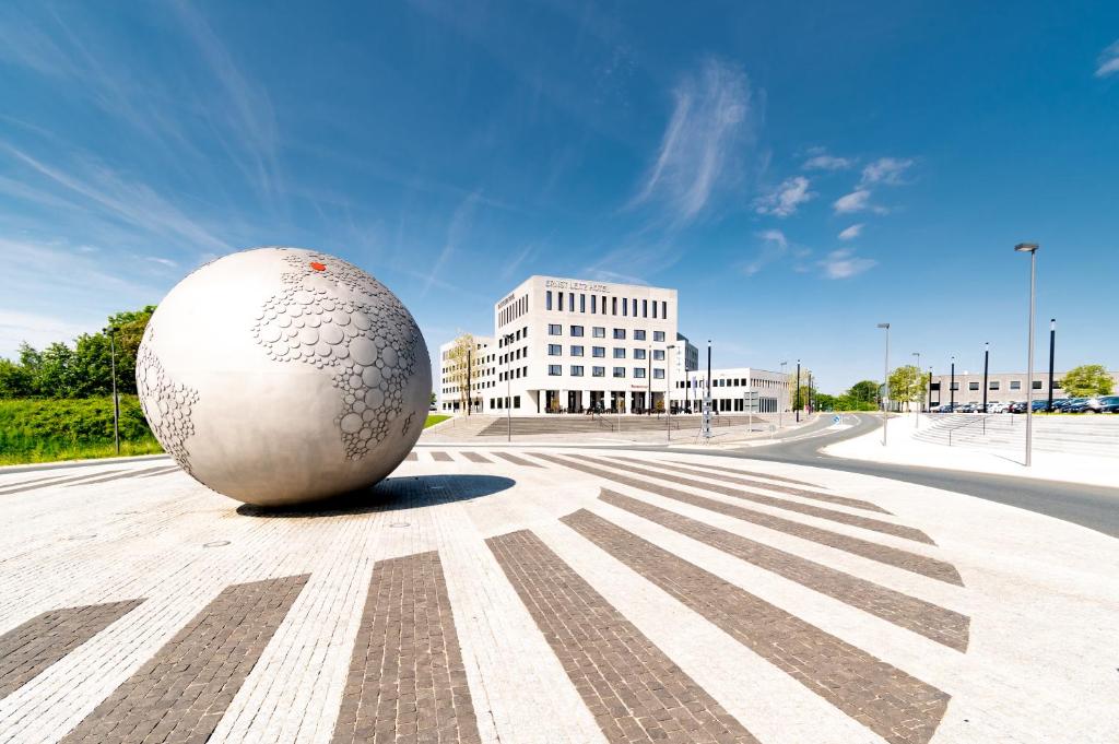 un gran huevo blanco sentado en medio de una calle en Vienna House by Wyndham Ernst Leitz Wetzlar en Wetzlar