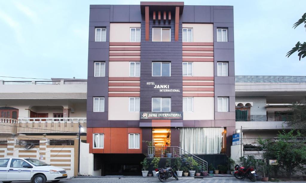 een hoog gebouw met een auto ervoor geparkeerd bij Hotel Janki International Sigra 2 KM From Kashi Vishwanath Temple in Varanasi