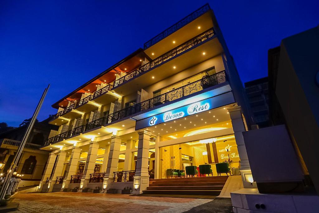 a large building with a lit up facade at night at Devon Rest in Kandy