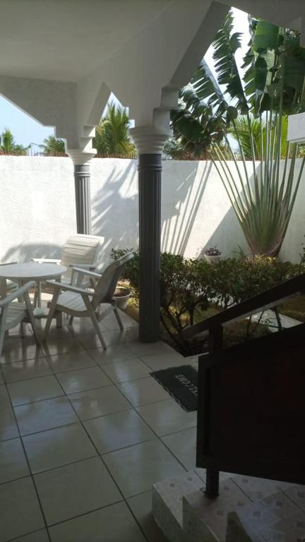 een patio met een tafel en stoelen op een veranda bij Villa à Lomé in Lomé