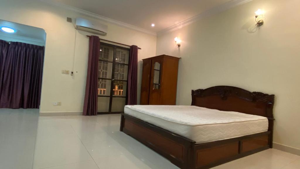1 dormitorio con 1 cama en la esquina de una habitación en Entire Town House in Chroy Changva area en Phnom Penh