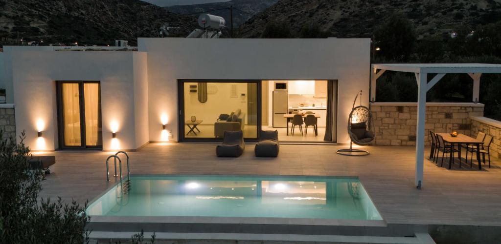 a villa with a swimming pool in front of a house at Anthelia Luxury Villas in Karpathos Town