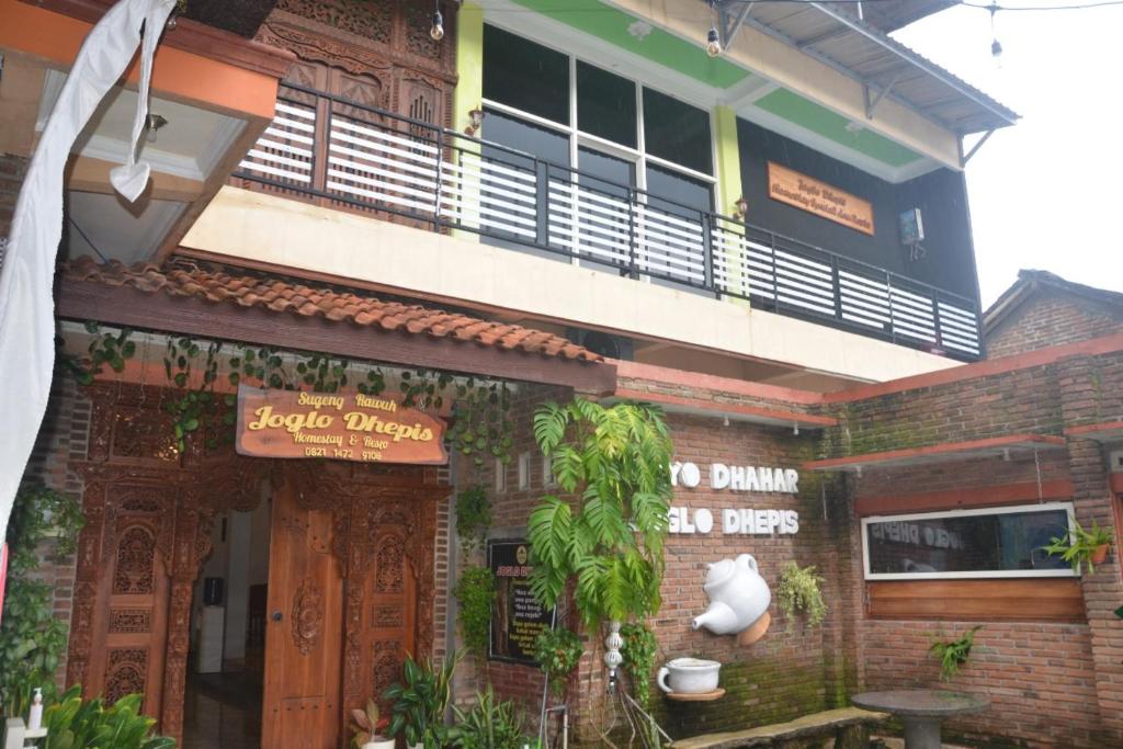 a building with a balcony on top of it at OYO 93736 Homestay Joglo Dephis Syariah in Magelang