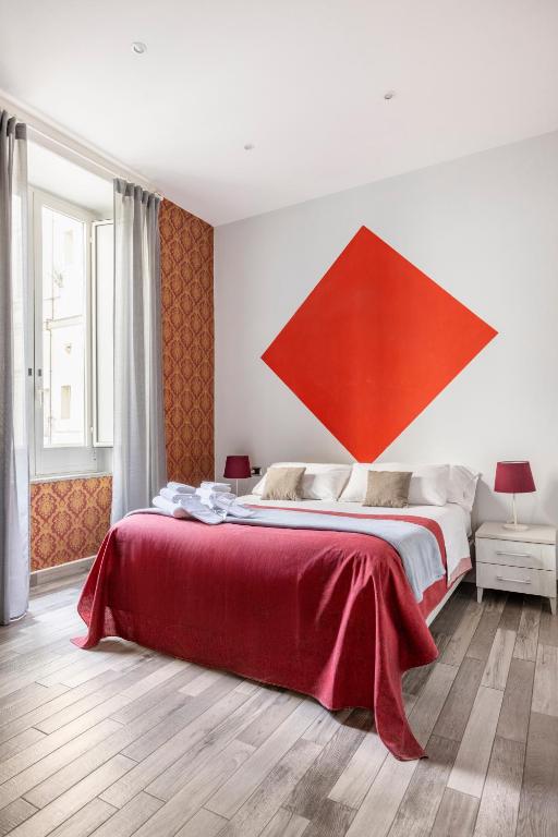 a bedroom with a bed with a large red painting on the wall at Scaramantico Rooms in Naples