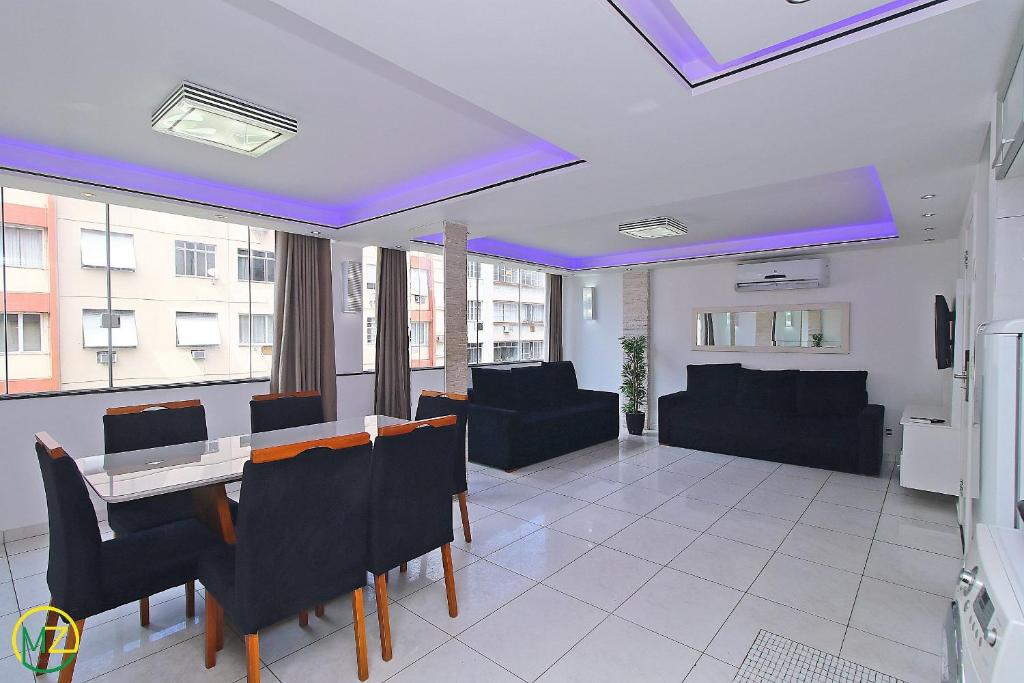 里約熱內盧的住宿－Moderno Apto 3 suites p/ 8 pessoas em Copacabana，客厅配有桌子和黑椅子