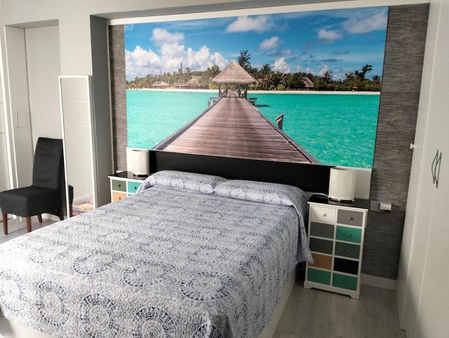 a bedroom with a wall mural of a pier at Casa Cris in Córdoba