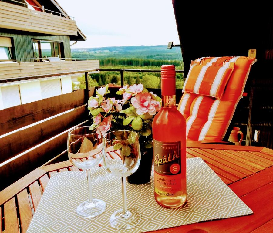 Una botella de vino y dos copas en una mesa. en Ferienwohnung Waldkäuzle27, en Lenzkirch