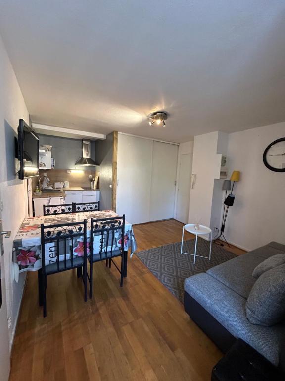 a living room with a couch and a kitchen at Appt entier rdc 1 chambre Allée d'Etigny in Luchon